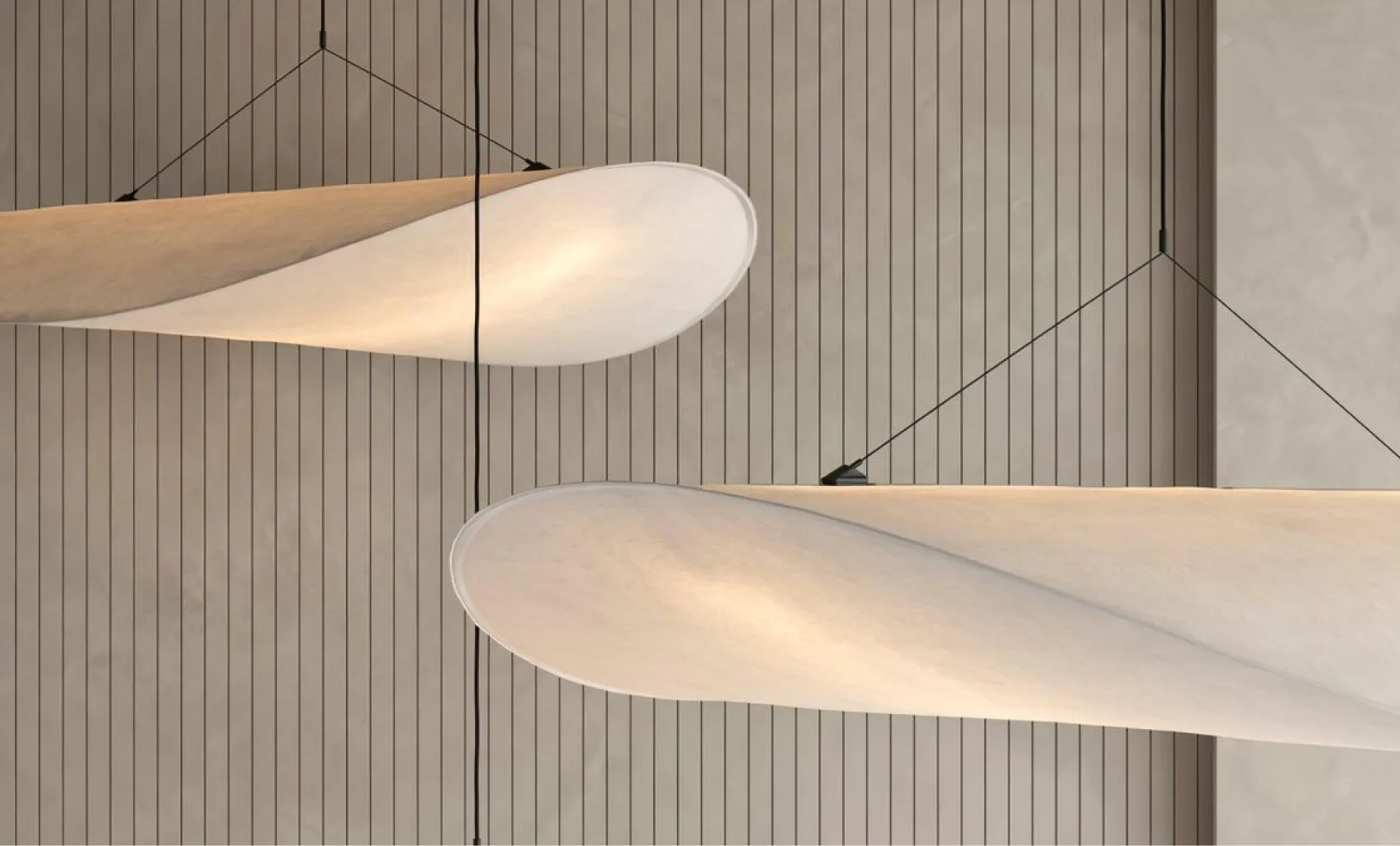 Sculptural pendant lights against a wood-slat wall